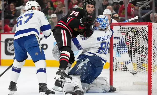 Chicago Blackhawks left wing Landon Slaggert (84) collides with Tampa Bay Lightning goaltender Andrei Vasilevskiy (88) during the second period of an NHL hockey game Friday, Jan. 23, 2026, in Chicago. (AP Photo/Erin Hooley)