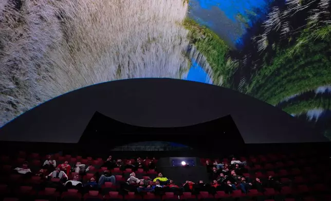 Audience members watch "Ohio: Wild at Heart" that features the state's top-rated park system to highlight wildlife conservation efforts and the restorative power of outdoor recreation at the Robert D. Lindner Family OMNIMAX Theater at the Cincinnati Union Terminal, Tuesday, Dec. 30, 2025, in Cincinnati. (AP Photo/Carolyn Kaster)