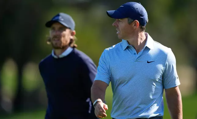 Rory McIlroy of Northern Ireland, right, and Tommy Fleetwood of England walk down the 16th fairway during the first round of the Dubai Desert Classic in United Arab Emirates, Thursday, Jan. 22, 2026. (AP Photo/Altaf Qadri)