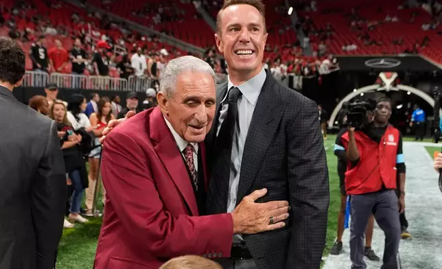 FILE - Atlanta Falcons owner Arthur Blank, left, talks to former quarterback Matt Ryan before an NFL football game against the Tampa Bay Buccaneers Oct. 3, 2024, in Atlanta. (AP Photo/John Bazemore, File)
