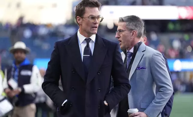 Former NFL player Tom Brady walks on the field before an NFL football divisional playoff game between the Seattle Seahawks and the San Francisco 49ers, Saturday, Jan. 17, 2026, in Seattle. (AP Photo/Lindsey Wasson)
