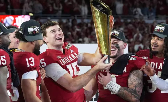Indiana quarterback Fernando Mendoza holds the trophy after their win against Miami in the College Football Playoff national championship game, Monday, Jan. 19, 2026, in Miami Gardens, Fla. (AP Photo/Marta Lavandier)
