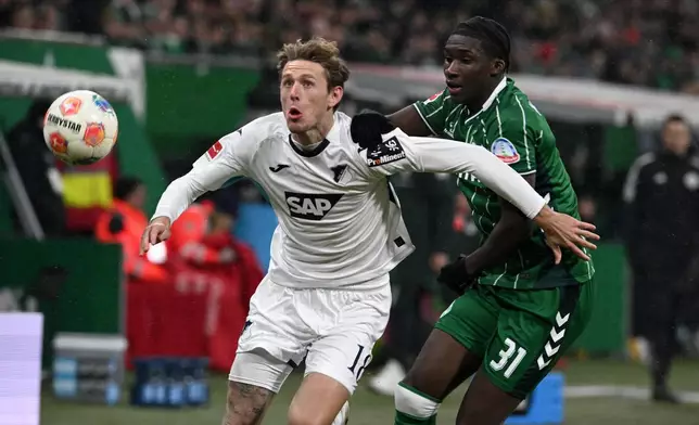 Hoffenheim's Wouter Burger, left, and Bremen's Karim Coulibaly fight for the ball during the German Bundesliga soccer match between Werder Bremen and TSG Hoffenheim 1899 in Bremen, Germany, Tuesday, Jan. 27, 2026. (Carmen Jaspersen/dpa via AP)