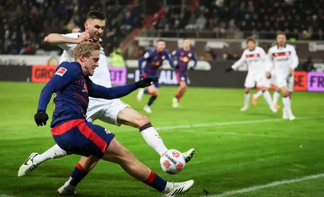 Leipzig's Xaver Schlager, left, and St. Pauli's Karol Mets battle for the ball during the German Bundesliga soccer match between FC St. Pauli and RB Leipzig in Hamburg, Germany, Tuesday, Jan. 27, 2026. (Christian Charisius/dpa via AP)