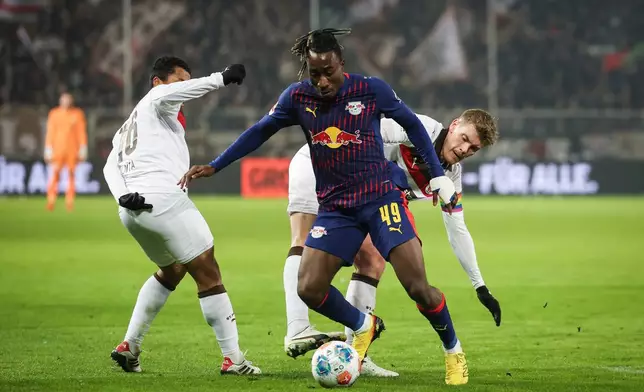 Leipzig's Yan Diomande, center, battles for the ball with St. Pauli's Eric Smith, right, and Joel Chima Fujita battle for the ball during the German Bundesliga soccer match between FC St. Pauli and RB Leipzig in Hamburg, Germany, Tuesday, Jan. 27, 2026. (Christian Charisius/dpa via AP)