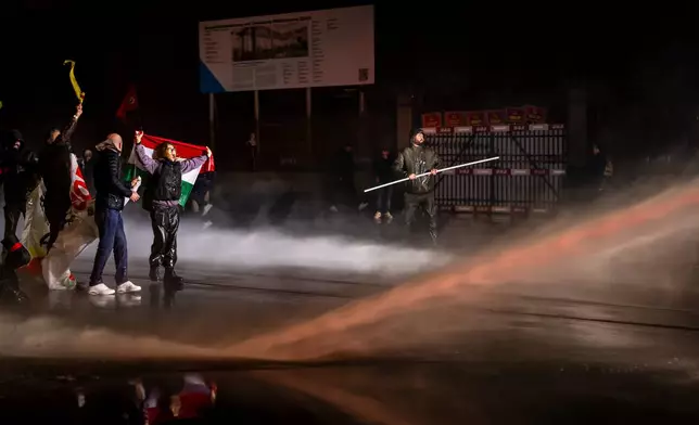 Protesters clash with riot police using water cannons and tear gas after a rally against the World Economic Forum in Davos and the visit of US President Donald Trump, on Monday, in Zurich, Switzerland, Jan. 19, 2026. (Michael Buholzer/Keystone via AP)