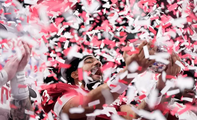 Indiana wide receiver Elijah Sarratt (13) holds up the trophy after the Peach Bowl NCAA college football playoff semifinal against Oregon, Friday, Jan. 9, 2026, in Atlanta. (AP Photo/Brynn Anderson)