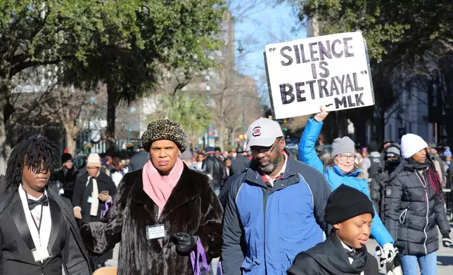FILE - A marcher holds up a sign at a march and rally at the South Carolina Statehouse to honor Martin Luther King Jr. on his holiday on Monday, Jan. 20, 2025, in Columbia, S.C. (AP Photo/Jeffrey Collins, File)