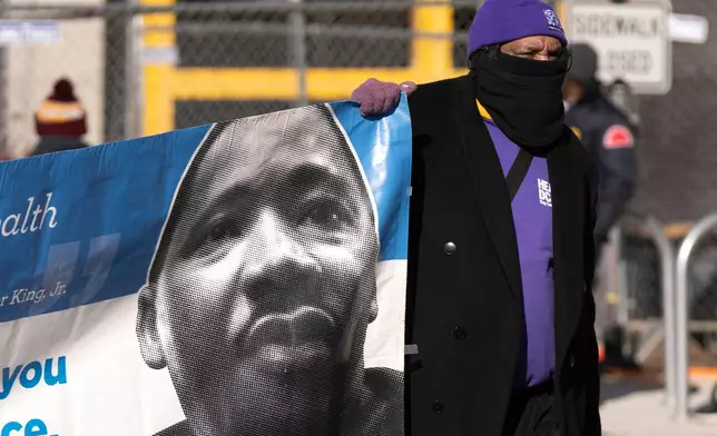 A participant carries a banner with an image of Martin Luther King, Jr., during the District of Columbia's annual Martin Luther King Day parade Monday, Jan. 19, 2026, in Washington. (AP Photo/Mark Schiefelbein)