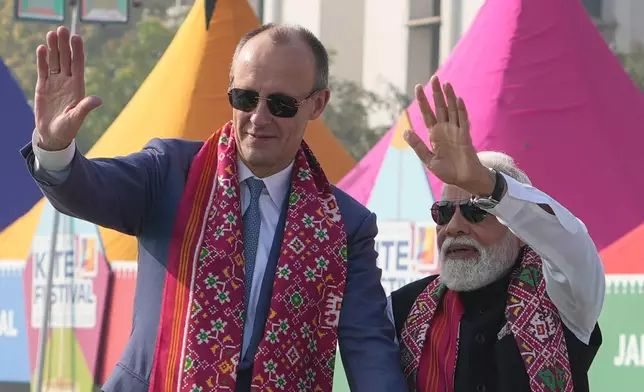 German Chancellor Friedrich Merz, left, and Indian Prime Minister Narendra Modi waves as they arrive for the inauguration of the International Kite Festival in Ahmedabad, India, Monday, Jan. 12, 2026. (AP Photo/Ajit Solanki)