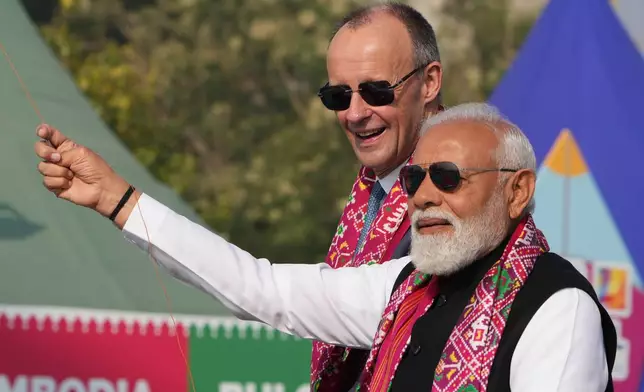 Indian Prime Minister Narendra Modi, right, and German Chancellor Friedrich Merz fly kites during the inauguration of International kite festival in Ahmedabad, India, Monday, Jan. 12, 2026. (AP Photo/Ajit Solanki)