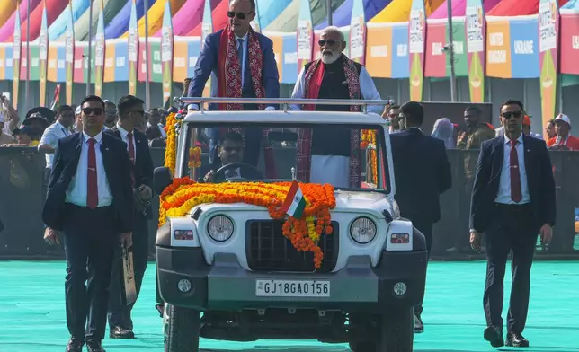 German Chancellor Friedrich Merz and Indian Prime Minister Narendra Modi ride together in a vehicle during the inauguration of International kite festival in Ahmedabad, India, Monday, Jan. 12, 2026. (AP Photo/Ajit Solanki)