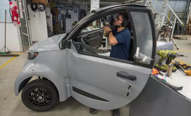 Ignacio Palacios works on a Sero Electric microcar at its factory in Castelar, Argentina, Wednesday, Jan. 21, 2026. (AP Photo/Victor R. Caivano)