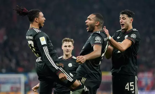 Bayern's Jonathan Tah celebrates with team mate Michael Olise after scoring his side's third goal during the Bundesliga soccer match between RB Leipzig and FC Bayern Munich in Leipzig, Germany, Saturday, Jan. 17, 2026. (AP Photo/Matthias Schrader)