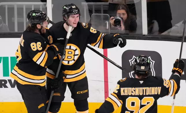 Boston Bruins center Fraser Minten, center, is congratulated after his goal against the Detroit Red Wings during the third period of an NHL hockey game, Tuesday, Jan. 13, 2026, in Boston. (AP Photo/Charles Krupa)