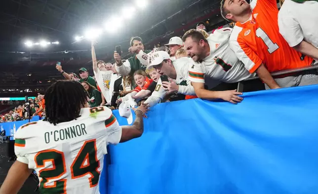 Miami defensive back Ethan O'Connor (24) celebrates with fans after winning the Fiesta Bowl NCAA college football playoff semifinal game against Mississippi, Thursday, Jan. 8, 2026, in Glendale, Ariz. (AP Photo/Ross D. Franklin)