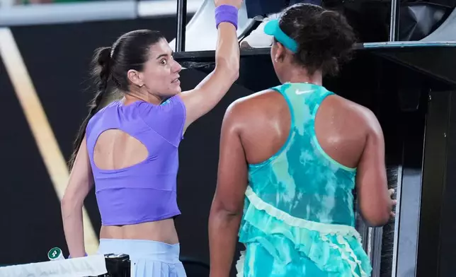 Sorana Cirstea, left, of Romania and Naomi Osaka of Japan talk at the net following their second round match at the Australian Open tennis championship in Melbourne, Australia, Thursday, Jan. 22, 2026. (AP Photo/Dita Alangkara)