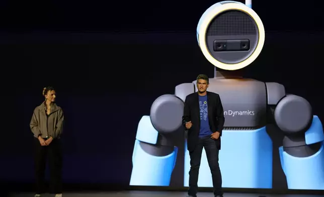 Humanoid application product lead at Boston Dynamics, Aya Durbin, left, and vice president and general manager of Atlas at Boston Dynamics, Zachary Jackowski, talk during a Hyundai and Boston Dynamics news conference ahead of the CES tech show, Monday, Jan. 5, 2026, in Las Vegas. (AP Photo/Abbie Parr)
