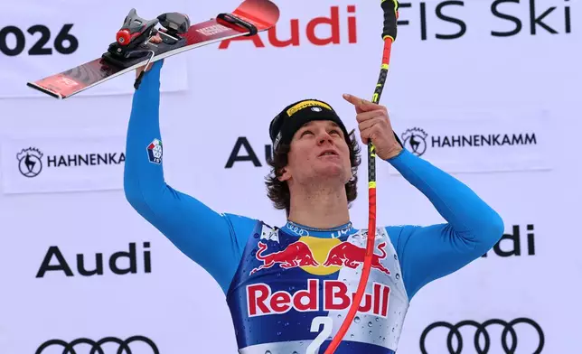 Italy's Giovanni Franzoni celebrates on podium winning a men's alpine ski World Cup downhill, in Kitzbuehel, Austria, Saturday, Jan. 24, 2026. (AP Photo/Marco Trovati)