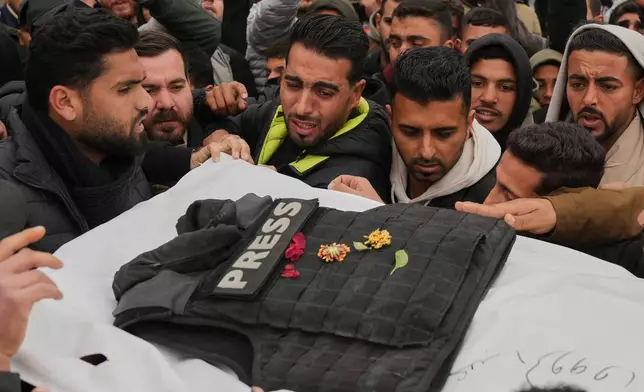 FILE - Mourners carry the body of Abd Shaat, one of the three Palestinian journalists who were killed in an Israeli strike on an Egyptian committee's vehicle, during his funeral in Khan Younis, southern Gaza Strip, Jan. 22, 2026. (AP Photo/Abdel Kareem Hana, File)