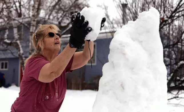 Bus driver Jackie Terry builds a snow sculpture for her students to enjoy along their bus route on Wednesday, Jan. 7, 2026 in Vergennes, Vt. (AP Photo/Amanda Swinhart)