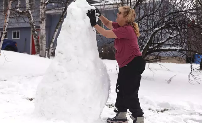 Bus driver Jackie Terry builds a snow sculpture for her students to enjoy along their bus route on Wednesday, Jan. 7, 2026 in Vergennes, Vt. (AP Photo/Amanda Swinhart)