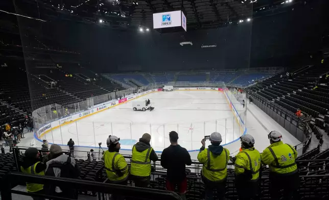 Workers take a break at the Santa Giulia Ice Hockey Arena, where Ice Hockey discipline of the Milan Cortina 2026 Winter Olympics will take place, in Milan, Italy, Friday, Jan. 9, 2026. (AP Photo/Luca Bruno)