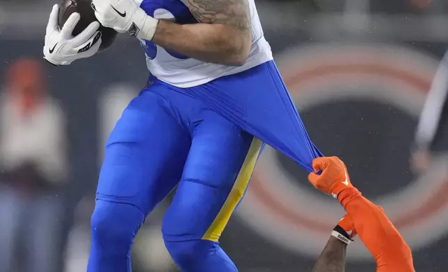 Chicago Bears safety C.J. Gardner-Johnson, bottom, grabs at the shirt of Los Angeles Rams tight end Tyler Higbee while defending on a catch during the first half of an NFL football divisional playoff game Sunday, Jan. 18, 2026, in Chicago. (AP Photo/Jeff Roberson)