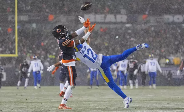 Chicago Bears safety Jaquan Brisker, left, breaks up a pass intended for Los Angeles Rams wide receiver Puka Nacua during the first half of an NFL football divisional playoff game Sunday, Jan. 18, 2026, in Chicago. (AP Photo/Jeff Roberson)