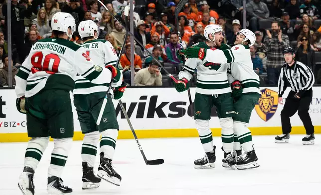 Minnesota Wild center Yakov Trenin, center, is greeted by Minnesota Wild defenseman Brock Faber (7) after scoring during the second period of an NHL hockey game against the Anaheim Ducks, Friday, Jan. 2, 2026, in Anaheim, Calif. (AP Photo/William Liang)