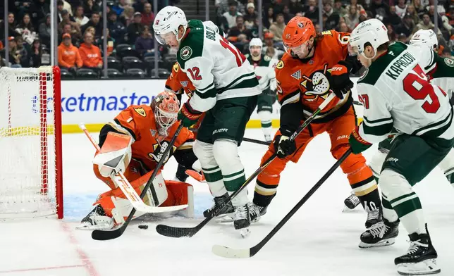 Minnesota Wild left wing Matt Boldy (12) looks to shoot while defended by Anaheim Ducks goaltender Lukas Dostal (1) during the second period of an NHL hockey game Friday, Jan. 2, 2026, in Anaheim, Calif. (AP Photo/William Liang)