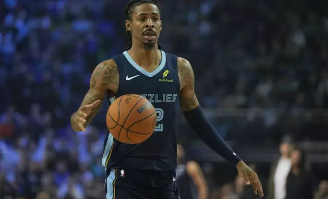 Memphis Grizzlies guard Ja Morant moves the ball during the second half of an NBA basketball game against the Orlando Magic Sunday, Jan. 18, 2026, in London. (AP Photo/Kin Cheung)