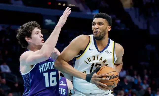 Indiana Pacers center Tony Bradley, right, drives into Charlotte Hornets forward PJ Hall, left, during the first half of an NBA basketball game in Charlotte, N.C., Thursday, Jan. 8, 2026. (AP Photo/Nell Redmond)