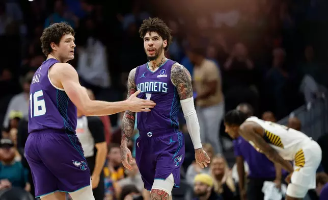 Charlotte Hornets guard LaMelo Ball (1) is congratulated by forward PJ Hall, left, after making a 3-point basket at the end of the first quarter of an NBA basketball game against the Indiana Pacers in Charlotte, N.C., Thursday, Jan. 8, 2026. (AP Photo/Nell Redmond)