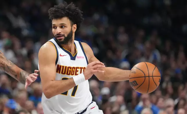 Denver Nuggets guard Jamal Murray drives to the basket against the Dallas Mavericks during the first half of an NBA basketball game Wednesday, Jan. 14, 2026, in Dallas. (AP Photo/Julio Cortez)