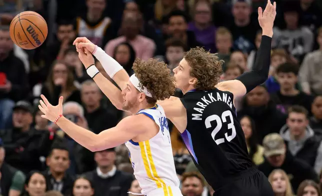 Golden State Warriors guard Brandin Podziemski, left, and Utah Jazz forward Lauri Markkanen, right, fight for possession of the loose ball during the first half of an NBA basketball game, Wednesday, Jan. 28, 2026, in Salt Lake City. (AP Photo/Tyler Tate)