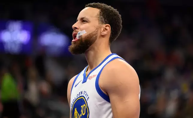 Golden State Warriors guard Stephen Curry reacts to making a 3-point shot during the first half of an NBA basketball game against the Utah Jazz, Wednesday, Jan. 28, 2026, in Salt Lake City. (AP Photo/Tyler Tate)