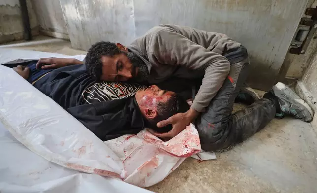 EDS NOTE: GRAPHIC CONTENT - Yusuf Zawara mourns over the body of his son, Mohammad Zawara, 15, who was killed in an Israeli strike, according to health officials, at Shifa Hospital, Gaza City, Saturday, Jan. 24, 2026. (AP Photo/Yousef Al Zanoun)