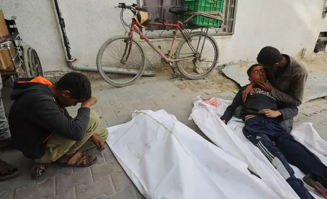 EDS NOTE: GRAPHIC CONTENT - Yusuf Zawara mourns over the body of his son, Mohammad Zawara, 15, who was killed along with his cousin Sulaiman Zawara, 13, in an Israeli strike, according to health officials, at Shifa Hospital, Gaza City, Saturday, Jan. 24, 2026. (AP Photo/Yousef Al Zanoun)