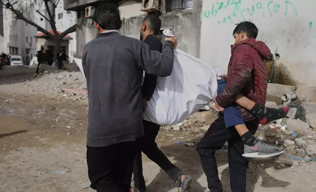 Palestinians carry the body of Mohammad Zawara, 15, who was killed in an Israeli strike, according to health officials, as they arrive at Shifa Hospital, Gaza City, Saturday, Jan. 24, 2026. (AP Photo/Yousef Al Zanoun)