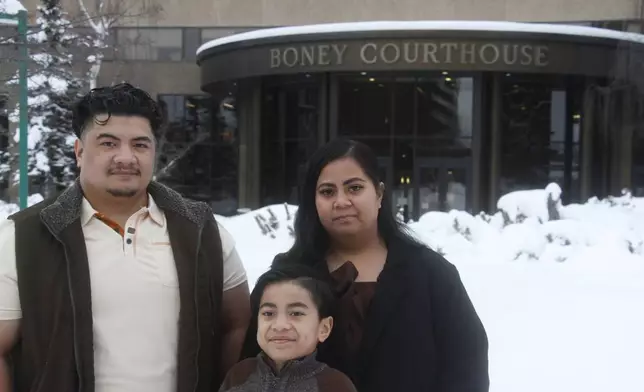 Michael Pese, left, his wife, Tupe Smith, and their son Maximus pose for a photo outside the Boney Courthouse in Anchorage, Alaska, Thursday, Jan. 15, 2026, ahead of the Alaska Court of Appeals hearing a challenge to the voter fraud case brought against her by the state. (AP Photo/Mark Thiessen)