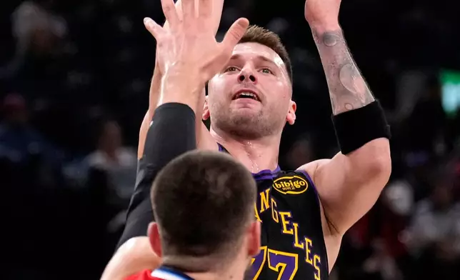 Los Angeles Lakers guard Luka Doncic, top, shoots as Los Angeles Clippers center Ivica Zubac defends during the first half of an NBA basketball game Thursday, Jan. 22, 2026, in Inglewood, Calif. (AP Photo/Mark J. Terrill)