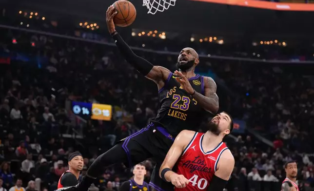 Los Angeles Lakers forward LeBron James, left, shoots as Los Angeles Clippers center Ivica Zubac defends during the first half of an NBA basketball game Thursday, Jan. 22, 2026, in Inglewood, Calif. (AP Photo/Mark J. Terrill)