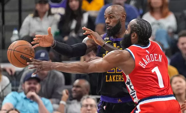 Los Angeles Clippers guard James Harden, right, passes as Los Angeles Lakers forward LeBron James defends during the first half of an NBA basketball game Thursday, Jan. 22, 2026, in Inglewood, Calif. (AP Photo/Mark J. Terrill)