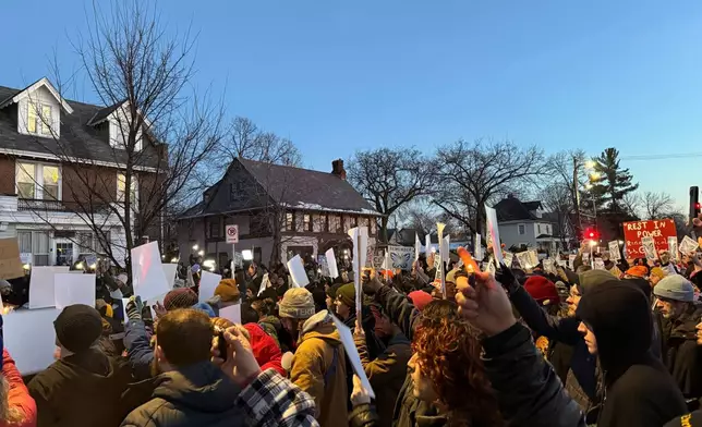 Demonstrators gather during a vigil near where an Immigration and Customs Enforcement officer shot and killed a woman in Minneapolis, Wednesday, Jan. 7, 2026. (AP Photo/Giovanna Dell'Orto)
