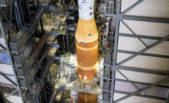 In this photo provided by NASA, the Artemis II SLS (Space Launch System) rocket and Orion spacecraft, secured to the mobile launcher, is seen inside the Vehicle Assembly building as preparations continue for roll out to Launch Pad 39B, Thursday, Jan. 15, 2026, at the Kennedy Space Center in Florida. (Aubrey Gemignani/NASA via AP)