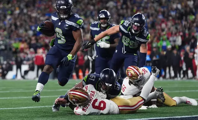 Seattle Seahawks running back Kenneth Walker III (9) scores a touchdown during the second half of an NFL football divisional playoff game against the San Francisco 49ers, Saturday, Jan. 17, 2026, in Seattle. (AP Photo/Lindsey Wasson)