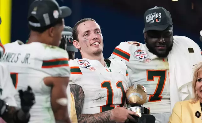 Miami quarterback Carson Beck (11) holds the offensive player of the game trophy after winning the Fiesta Bowl NCAA college football playoff semifinal game against Mississippi, Thursday, Jan. 8, 2026, in Glendale, Ariz. (AP Photo/Ross D. Franklin)