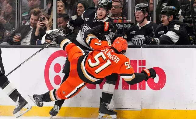 Los Angeles Kings left wing Jeff Malott, top, knocks Anaheim Ducks defenseman Olen Zellweger to the ice during the second period of an NHL hockey game Friday, Jan. 16, 2026, in Los Angeles. (AP Photo/Mark J. Terrill)