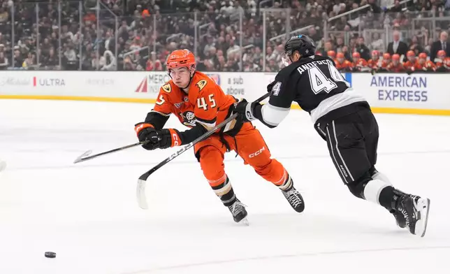 Anaheim Ducks right wing Beckett Sennecke, left, passes the puck while under pressure from Los Angeles Kings defenseman Mikey Anderson during the first period of an NHL hockey game Friday, Jan. 16, 2026, in Los Angeles. (AP Photo/Mark J. Terrill)